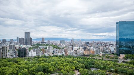 Cityscapes of the skyline in Osaka, with garden park in foregroundの写真素材