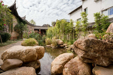 Traditional Chinese garden, a tourist attraction at Wolong College in Changting city, with ancient wood buildings, stones, and small lakeのeditorial素材