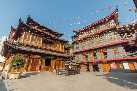 Hongshan Temple with traditional Chinese buddhistic buildings and incense burner against blue sky in Xiamen, Chinaのeditorial素材
