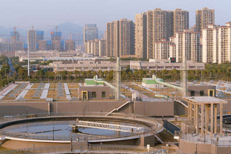 Water Purification Plant from Above, with modern city skyline at distanceのeditorial素材