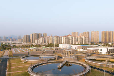 Water Purification Plant from Above, with modern city skyline at distanceのeditorial素材