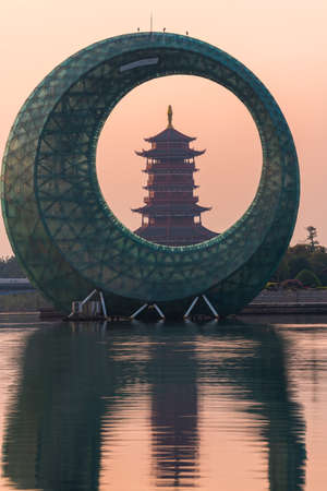 Sunrise landscapes with a Chinese traditional pagoda and moon like architecture building on lake, in Xinglin Bay, Xiamen, Chinaのeditorial素材