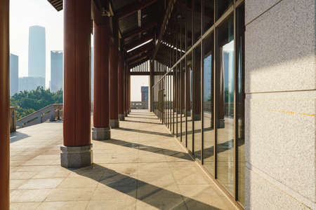 Chinese retro corridor and city skyline with red pillars under the sunlight