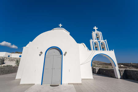 Traditional blue dome church and white bell tower in Santorini in Greeceの写真素材