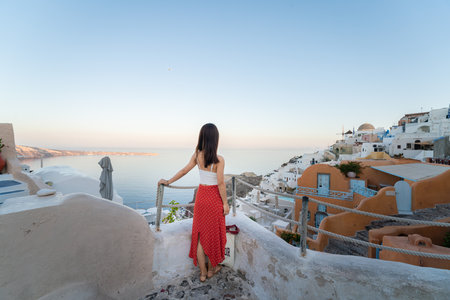 Asian women in dresses traveling in Santorini, Greeceの写真素材
