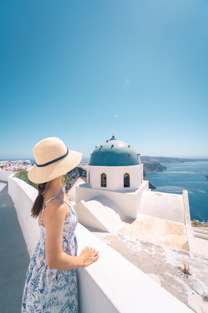 Asian women in dresses traveling in Santorini, Greeceの写真素材