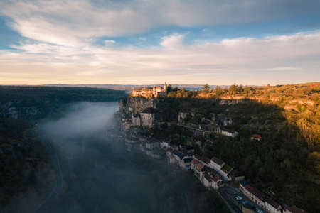 Rocamadour sunrise, Aerial view of the french village and castle on cliff in early morning with fogs in the Canyon of the Alzouのeditorial素材