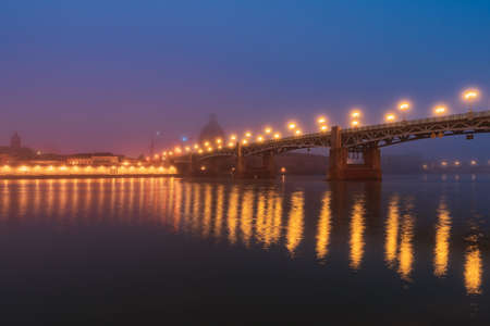 Garonne river and Dome of the 'Hopital de la Grave' at sunrise in fog in Toulouse, France