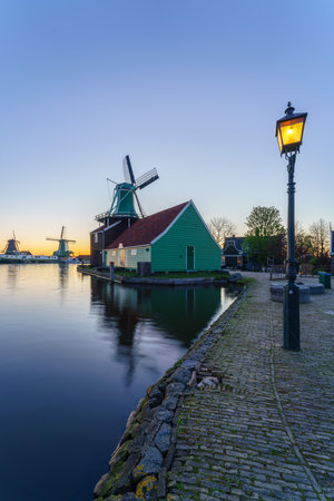 Historical buildings and windmills at dawn in Zaanse Schans, Netherlandsのeditorial素材