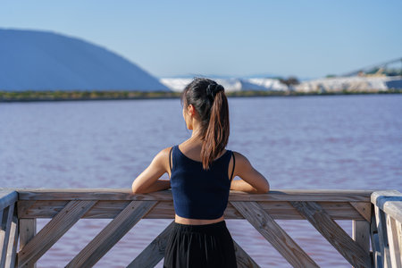 Woman wearing a sport vest with pink salt lake in the backgroundの写真素材
