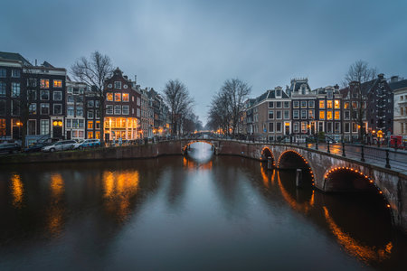 Evening panoramic view of the famous historic center with lights, bridges, canals and traditional Dutch houses in Amsterdam, Netherlandsの写真素材