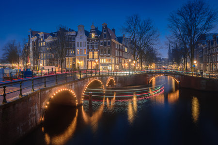 Evening panoramic view of the famous historic center with lights, bridges, canals and traditional Dutch houses in Amsterdam, Netherlandsの写真素材