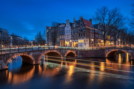 Evening panoramic view of the famous historic center with lights, bridges, canals and traditional Dutch houses in Amsterdam, Netherlandsの写真素材