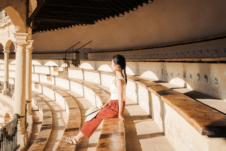 A woman sitting on the seat in the Plaza de Toros de Ronda, a historic Bullring in Ronda, Spainの写真素材