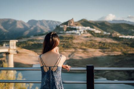 Woman in travel, Asian woman in blue dress looking at the old city, Zahara de la Sierra in Cadiz, Spainの写真素材