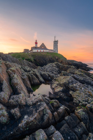 Saint-Mathieu Lighthouse at sunrise, with cliff rocks on foreground, on Pointe Saint-Mathieu in Plougonvelin, Brest, Franceの写真素材