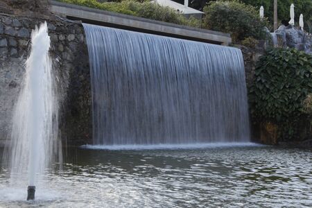 Big rock waterfall into tropical garden