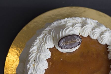 white cream cake on gold plate with back background. San marcos cake. Felicidades signal.の写真素材