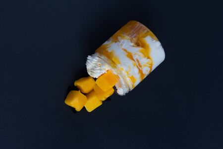 A piece of mango cheese cake on white background as a studio shot. Overviewの写真素材