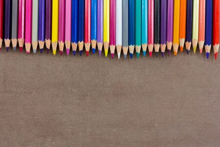 Color pencils, sharpener and shavings on black board