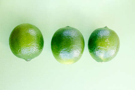 One fresh green lime overhead view lemon background