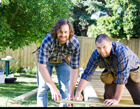 Carpenters checking their measurements on boardの写真素材