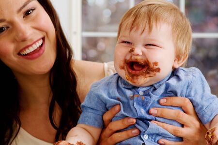 Mom and babe enjoying chocolate icingの写真素材