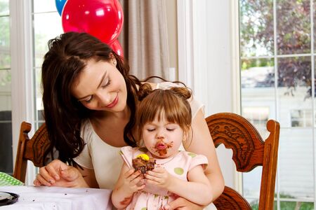 Young gal enjoying her chocolate cupcakeの写真素材