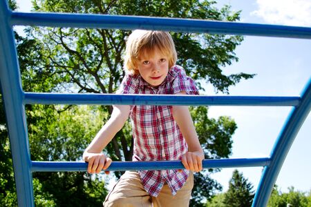 Young lad climbing bars on playground