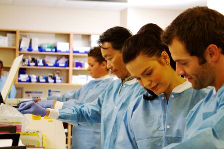 Four laboratory technicians in hospital processing specimens