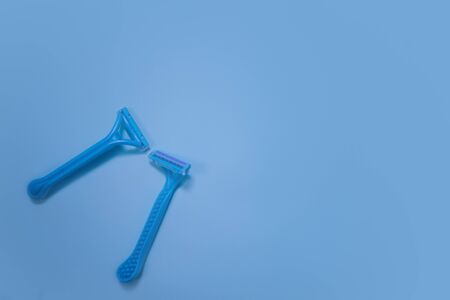Removal of unwanted hair, concept. Disposable shaving machines for men and women. Flat lay blue backgroundの写真素材