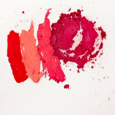 Lipstick and lip gloss, drops and strokes of different shades to create different images in makeup, white backgroundの写真素材
