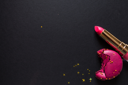 flat lay template, in glamorous chic style, black background, scarlet lipstick and gold sequins. free space in the centerの写真素材