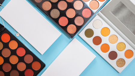Large sets of eye shadows and concealers, cosmetics for professional makeup artist, blue backgroundの写真素材