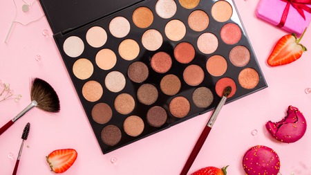 Eyeshadows and correctors, a large palette of make-up artist, Cute pink flat lay. Glamorous style, elements cosmetics and sweets on frameの写真素材