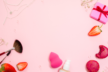 Cute pink flat lay, template with free space in the center for your design. Glamorous style, elements cosmetics and sweets on frameの写真素材