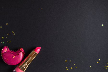 flat lay template, in glamorous chic style, black background, scarlet lipstick and gold sequins. free space in the centerの写真素材