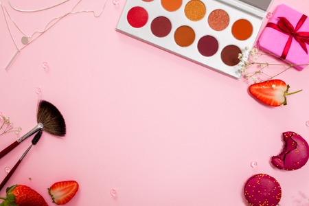 Cute pink flat lay, template with free space in the center for your design. Glamorous style, elements cosmetics and sweets on frameの写真素材