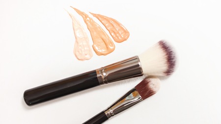 Foundation cream drops and smears of different shades for different skin types with brushes for application and shading. Cosmetics and make-up ,skin care and beauty conceptの写真素材