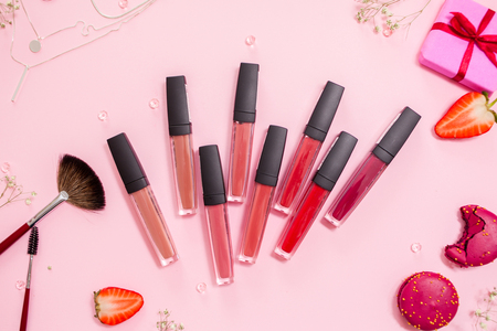 Cute pink flat layand lipstick with lip gloss in the center. Glamorous style, elements cosmetics and sweets on frameの写真素材