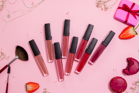 Cute pink flat layand lipstick with lip gloss in the center. Glamorous style, elements cosmetics and sweets on frameの写真素材