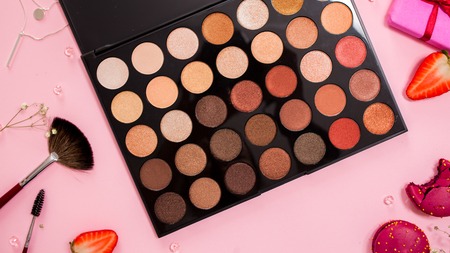 set of different eyeshadow in the Nude palette, Cute pink flat lay. Glamorous style, elements cosmetics and sweets on frameの写真素材