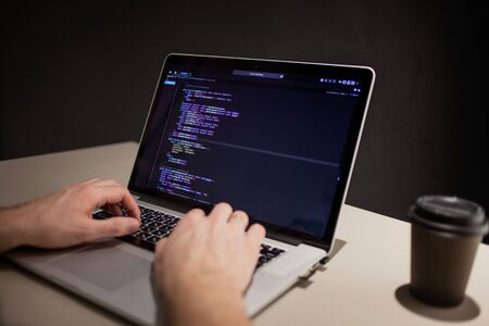 Programmer and coder working in the development environment. Programmer's workplace, laptop with...