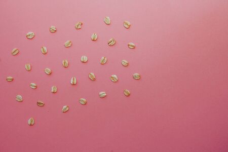 pattern of grains of oats on a pink background. Oat flakes for a healthy diet.の写真素材