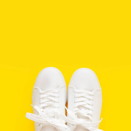 Perfect white New sneakers standing on a bright yellow background. Only half is visible.の写真素材