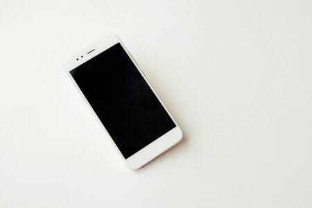 White smartphone on white background mockup. Phone, modern technologies social networks and applications. Copy spaceの写真素材