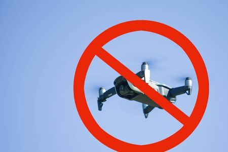 no-fly zone. Quadcopter drone flying in nature against the blue sky. The maneuver. Enclosed in red prohibition sign. Crossed out circle.の写真素材