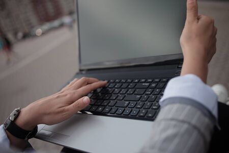Young ambitious woman with a laptopworks on a laptop during a break. Woman with laptop outdoors.