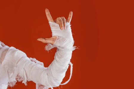 Halloween, costume image. The mummy's hand in bandages making gestures. Super gesture, rock n roll...