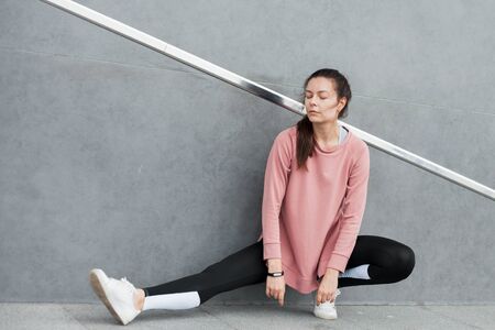 Fitness sport girl resting after intensive evening run, young attractive runner taking break after...